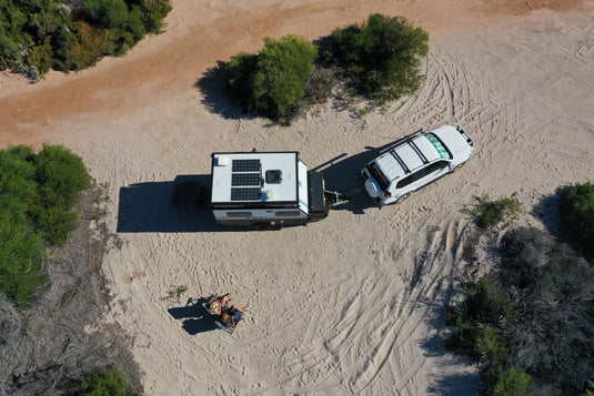 drone image of couple sitting next to caravan parked